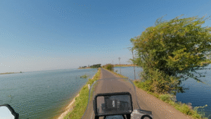 मौलीपाड़ा के पास पानी के बीच संकरे रास्ते पर बाइक राइड का POV दृश्य